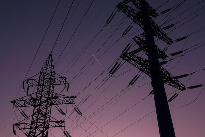 2 cell towers over a purple-blue hazy sky