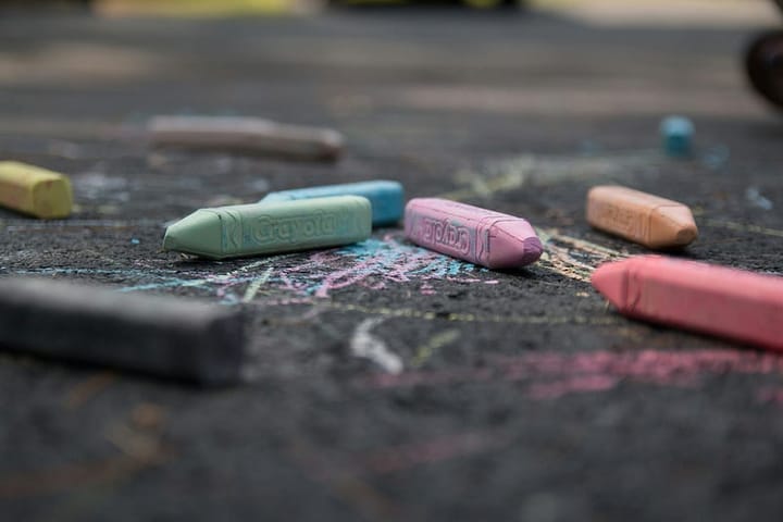 close-up of coloured chalk pencils on pavement