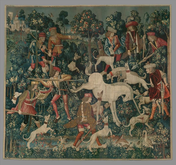 Tapestry depicting a white unicorn being attacked by several courtiers with white hunting dogs in an orchard overlooked by a